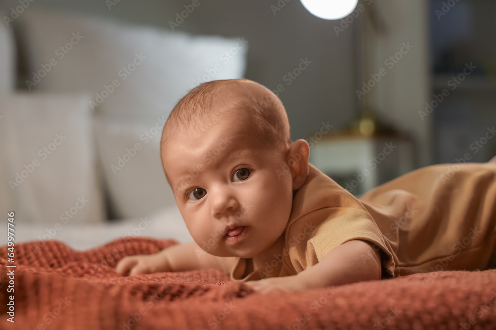 Cute little baby lying on bed at night, closeup