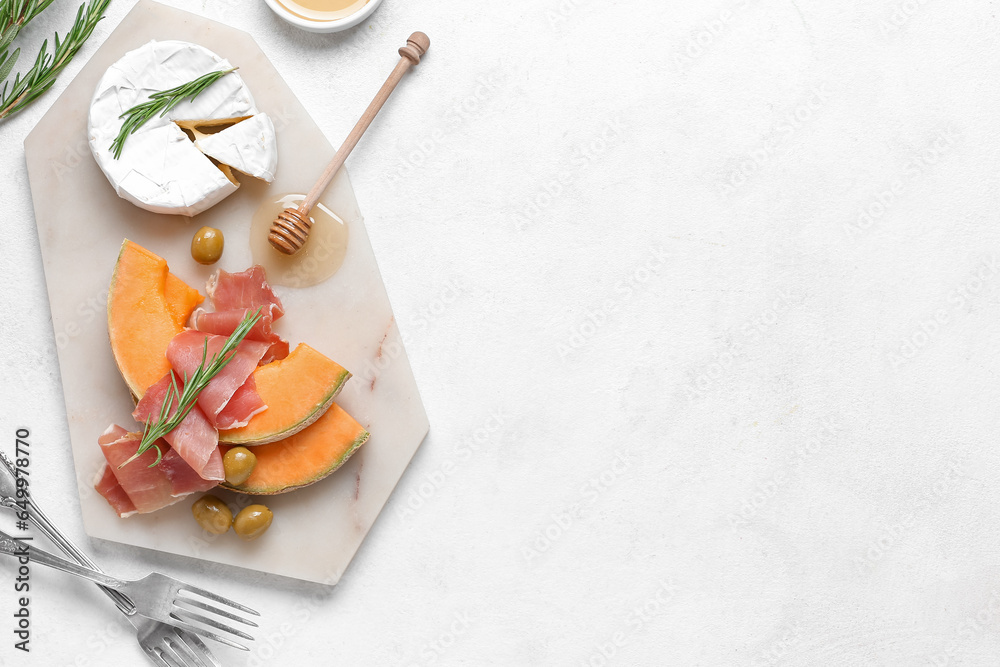 Composition with tasty melon, prosciutto, cheese and honey on light background