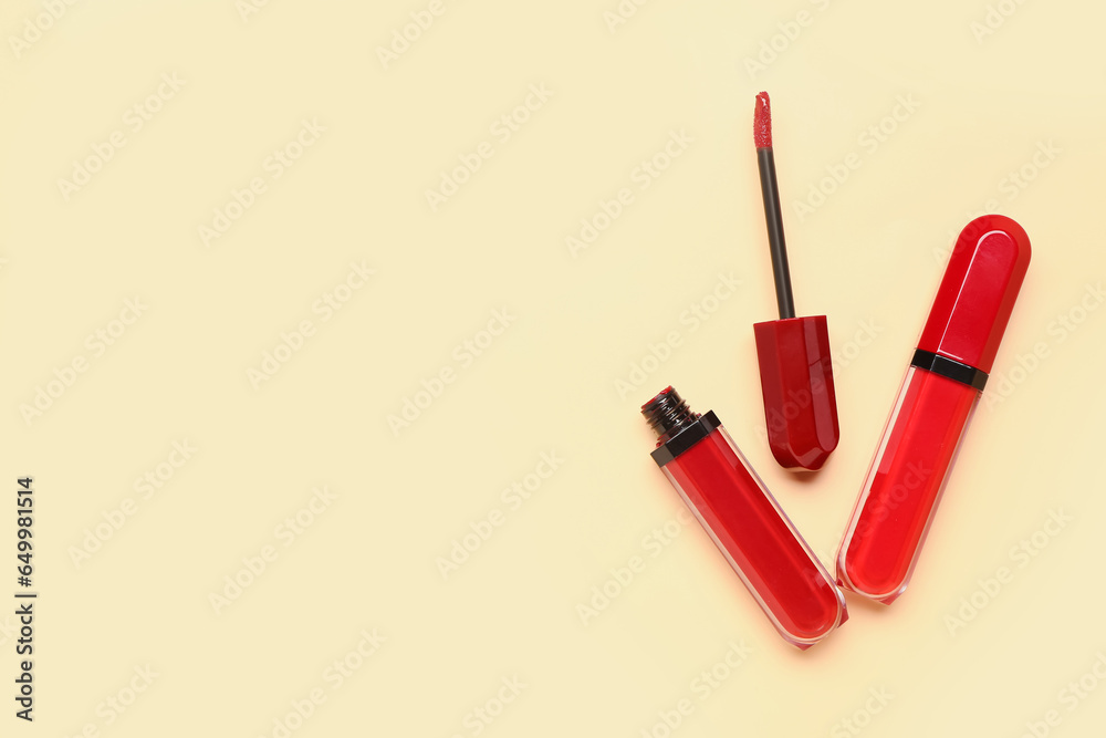 Different red lipsticks with brush on beige background