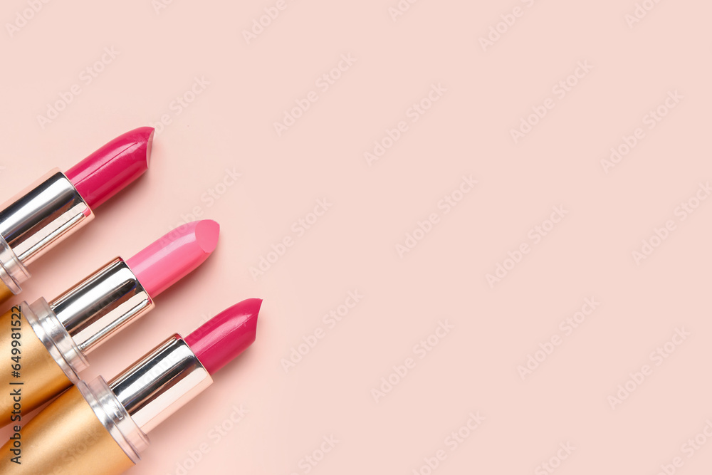 Different bright lipsticks on pink background