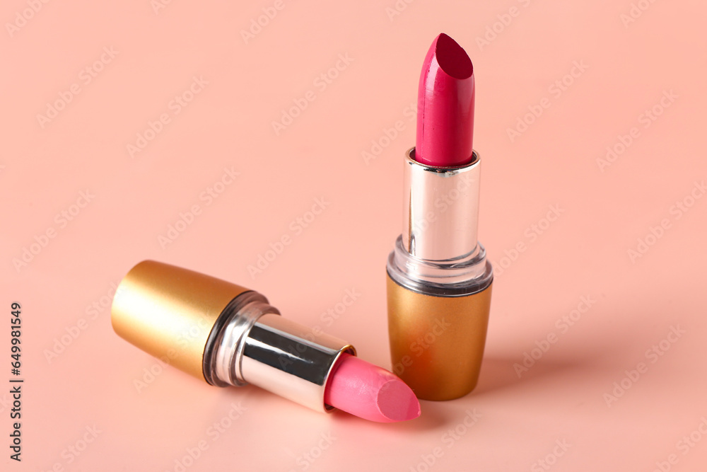 Different stylish lipsticks on pink background