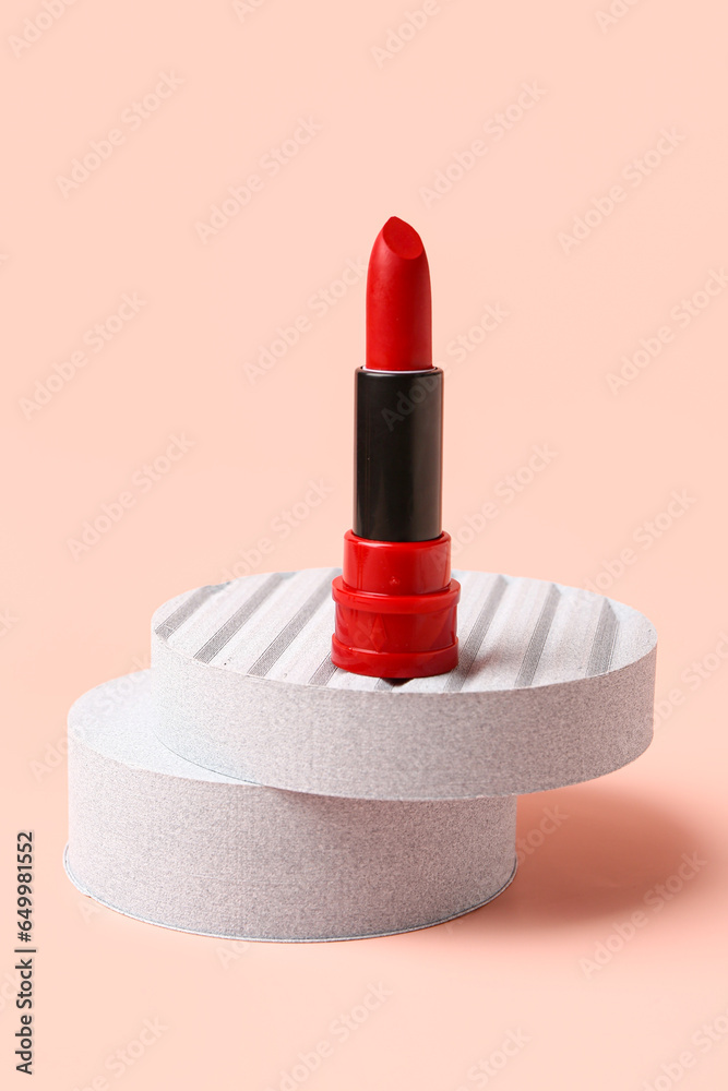 Stand with new red lipstick on pink background