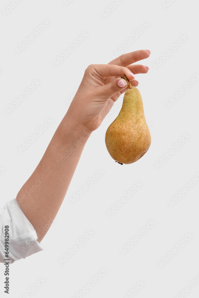 Woman holding ripe pear on white background