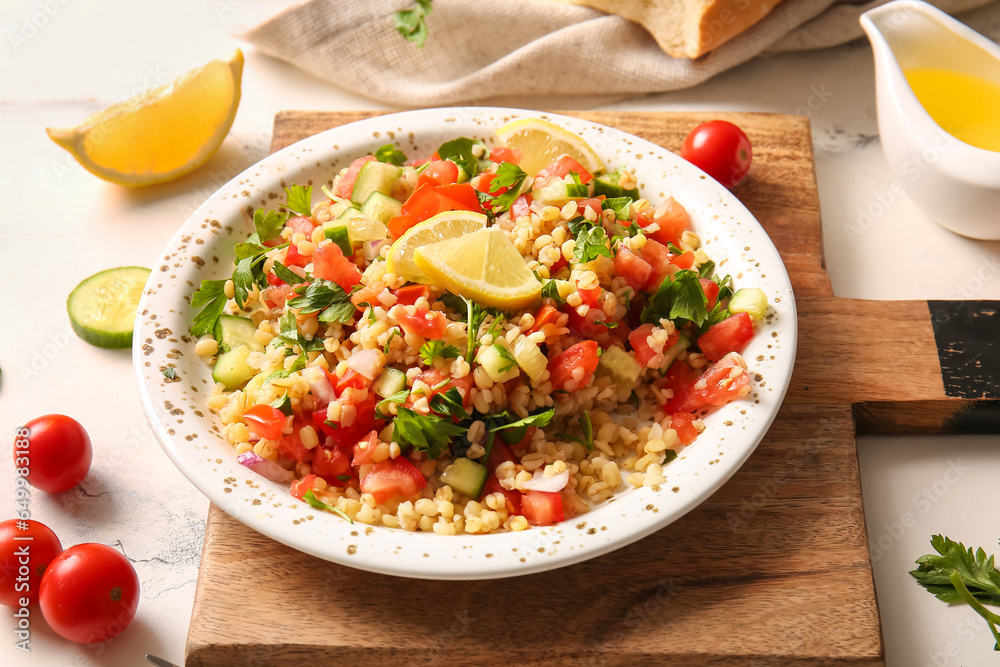 Plate with delicious tabbouleh salad on light background, closeup