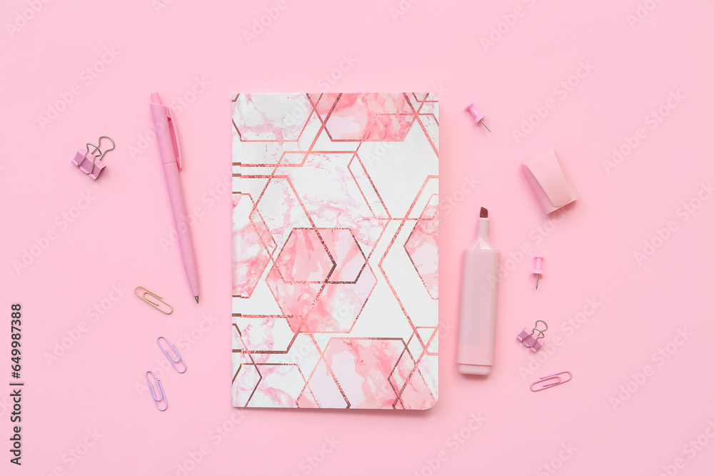 Composition with notebook, paper clips, pen and marker on pink background