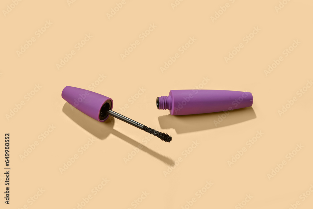 Black mascara in purple tube on yellow background