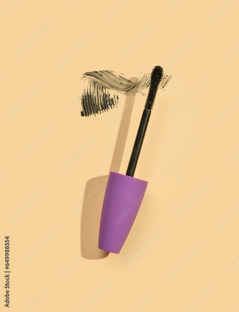 Black mascara brush with sample on yellow background