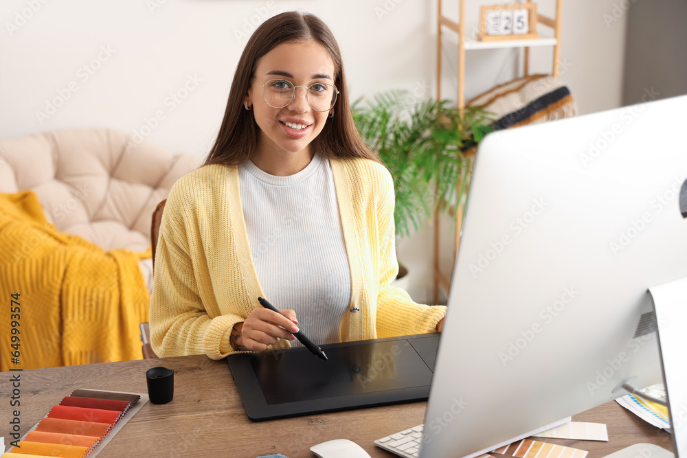 Female interior designer working with graphic tablet at table in office