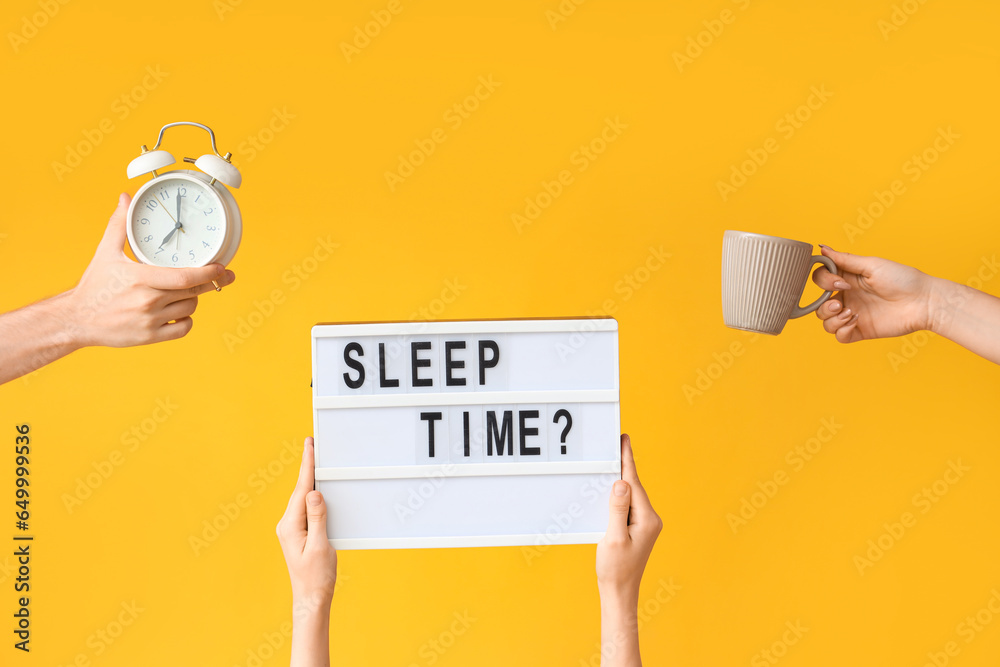 Hands holding alarm clock, cup and board with question SLEEP TIME? on yellow background