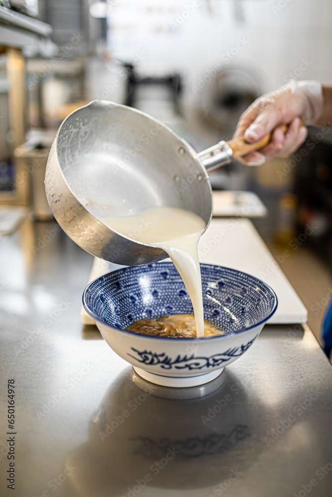 Chef making japanese ramen noodle soup in restaurant