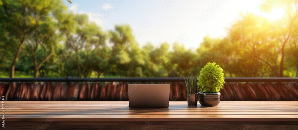 Nature view terrace with wooden flooring rattan and fabric furniture and a laptop on the table giving the impression of work