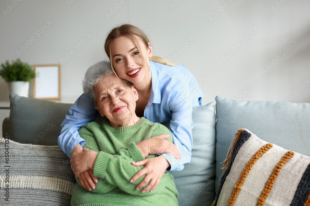 Young woman and her grandmother hugging at home