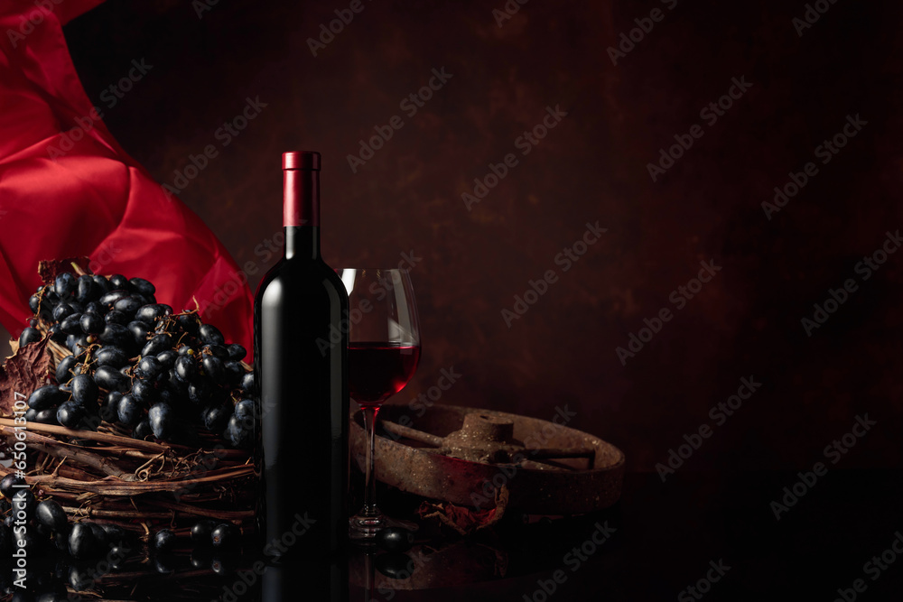 Red wine with grapes on a background of red flutters curtain.