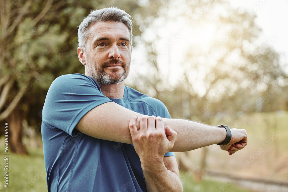 Mature man, arm stretching and outdoor for fitness, wellness and exercise in a park for health. Morning, athlete and training in nature with workout and sports of a calm person ready to start run