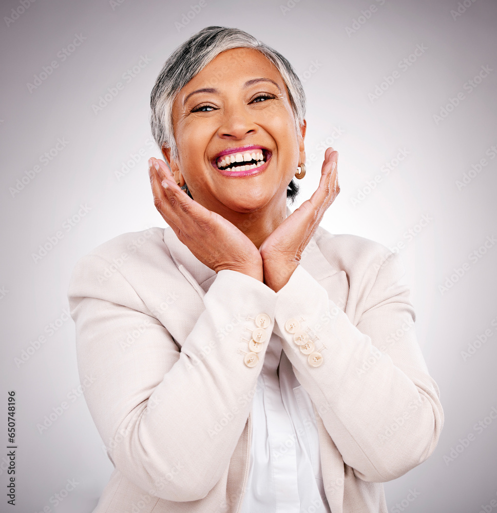 Portrait, funny and a mature business woman laughing in studio on a gray background for smile or professional growth. Comic, corporate and face frame with happy professional looking confident in suit