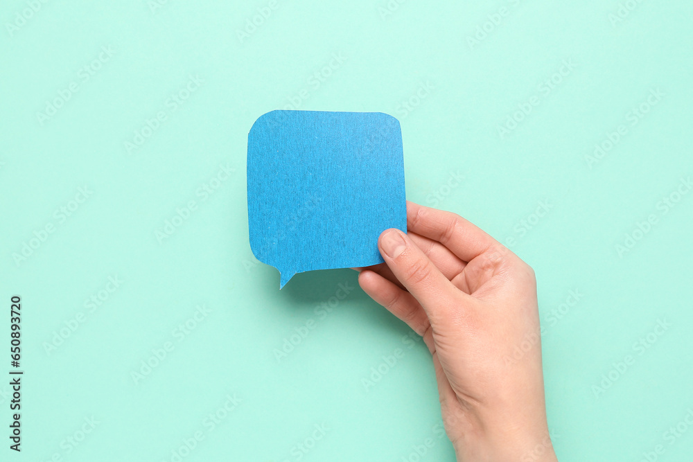 Woman holding blank speech bubble on turquoise background