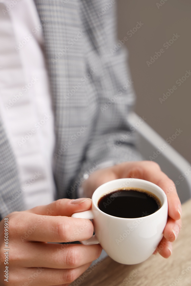 Woman holding cup of delicious coffee, closeup