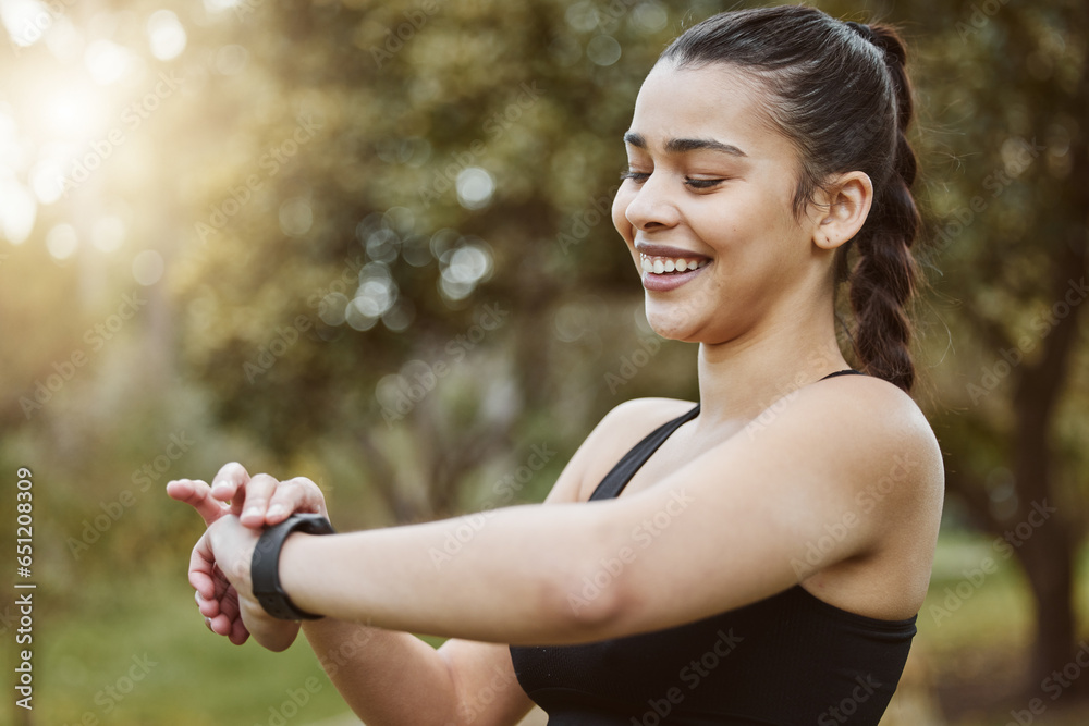 Happy runner woman, smart watch and park for check, smile or reading for time, results or fitness in nature. Girl, iot clock and monitor for speed, heart rate or smile for exercise, workout or health