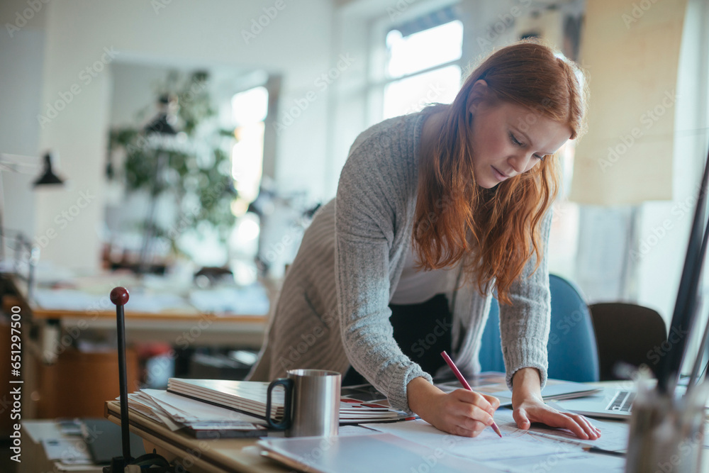 Young female architect working on a project in a modern business office