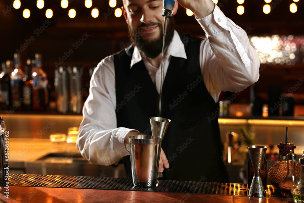 Bartender making fresh alcoholic cocktail at bar counter, selective focus