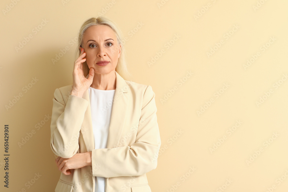 Mature blonde woman on beige background