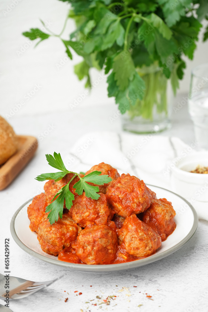 Plate of tasty meat balls with sauce on light background