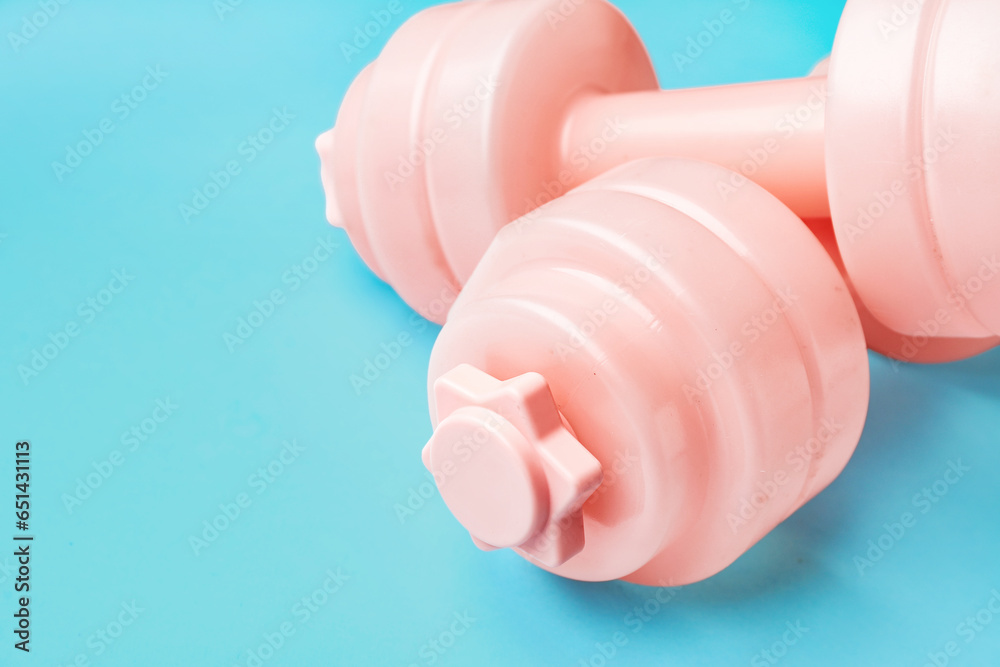 Pink dumbbells on blue background