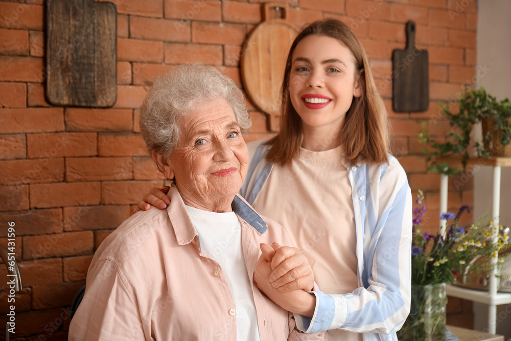 Young woman with her grandmother holding hands in kitchen