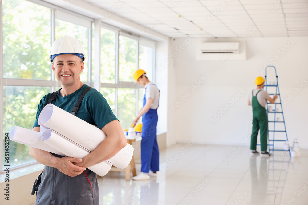 Mature builder with paper rolls in room