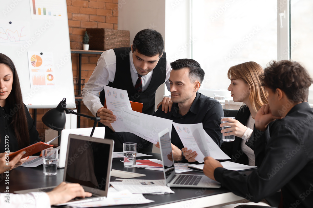 Group of business consultants working at table in office