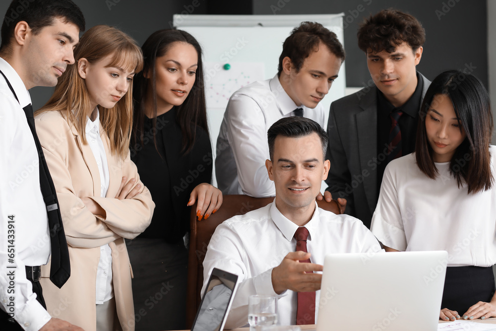 Group of business consultants working with laptop at table in office