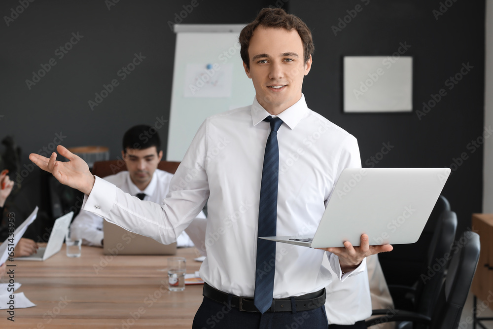 Male business consultant with laptop working in office