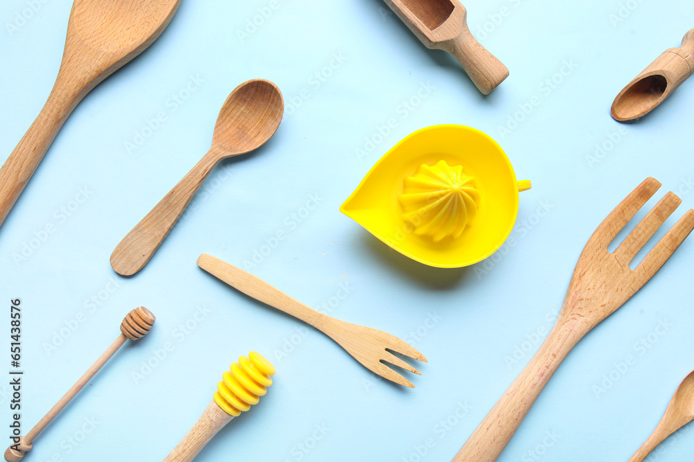 Set of different kitchen utensils with citrus juicer on color background