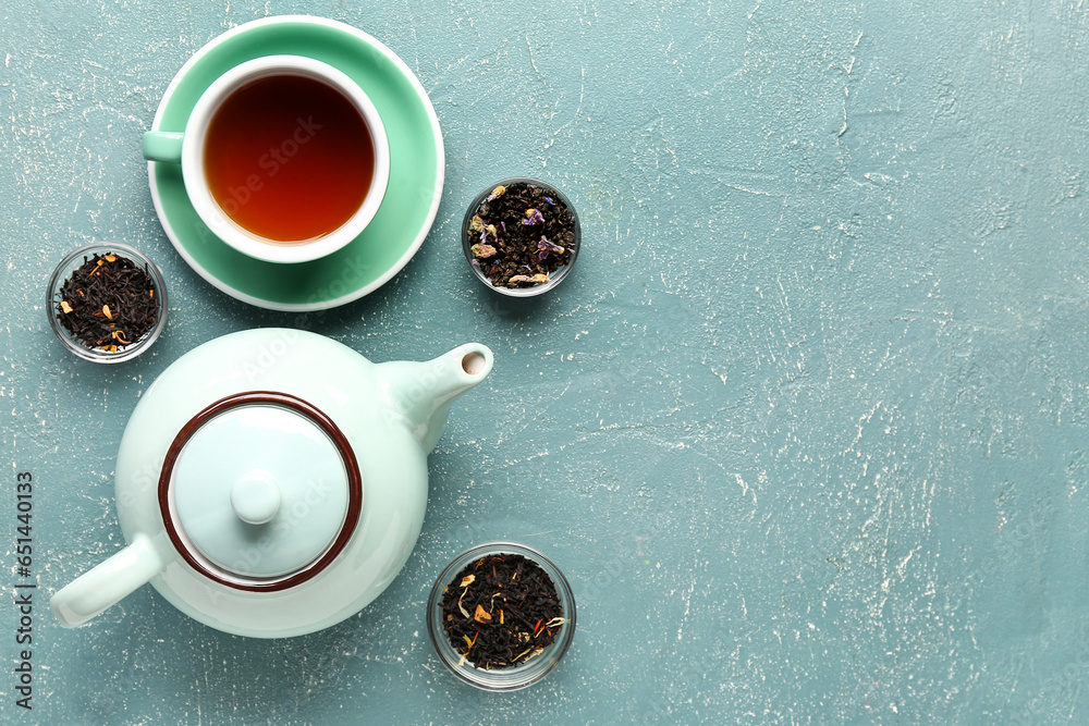 Teapot, different types of tea and cup of beverage on color background