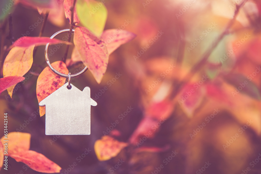 The symbol of the house hangs against the red autumn leaves 