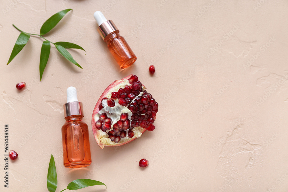 Composition with bottles of essential oil, ripe pomegranate and plant branches on color background