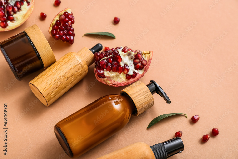 Composition with different cosmetic products and pomegranate on color background, closeup