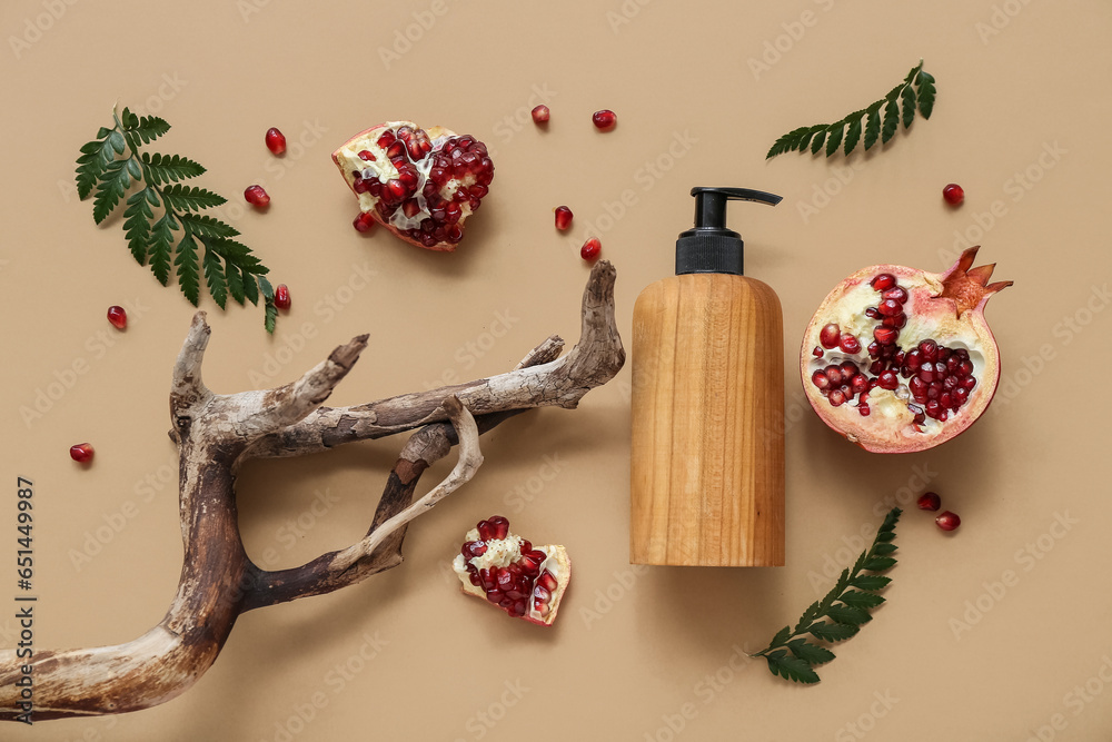 Composition with bottle of cosmetic product, pomegranate and tree branch on color background