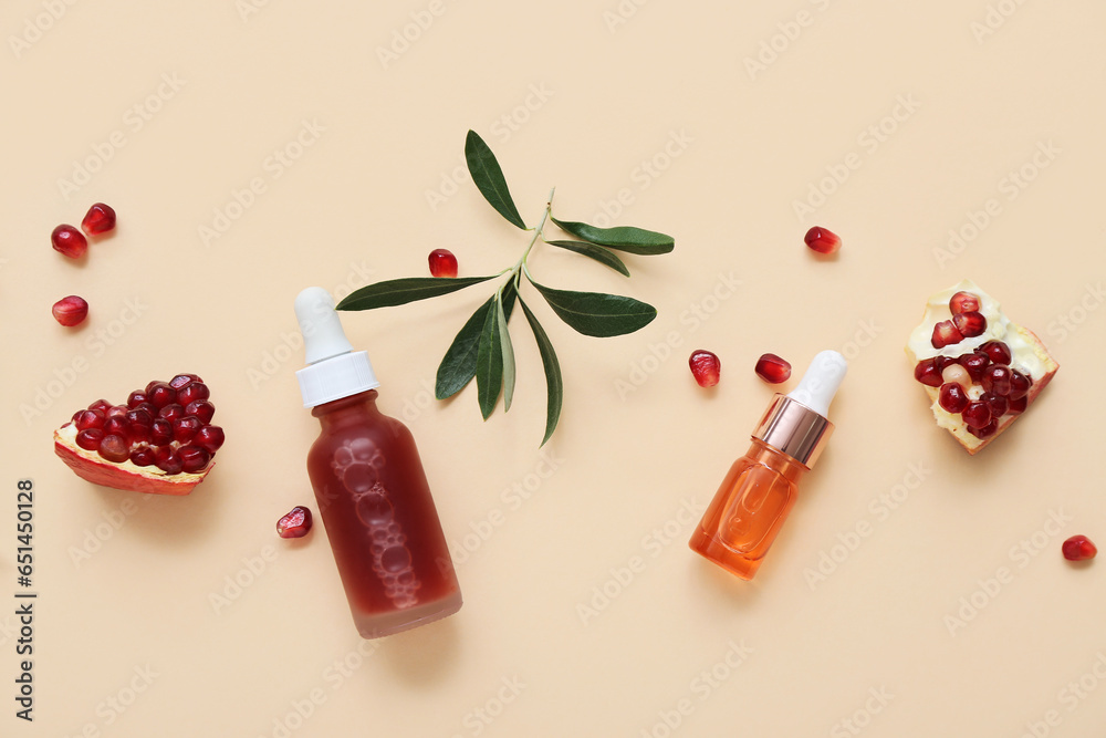 Composition with bottles of essential oil, pomegranate and plant branch on color background