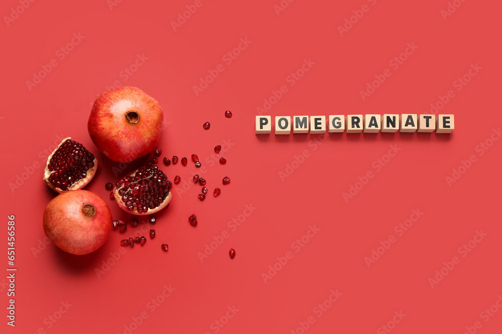 Word POMEGRANATE and fresh fruits with seeds on red background