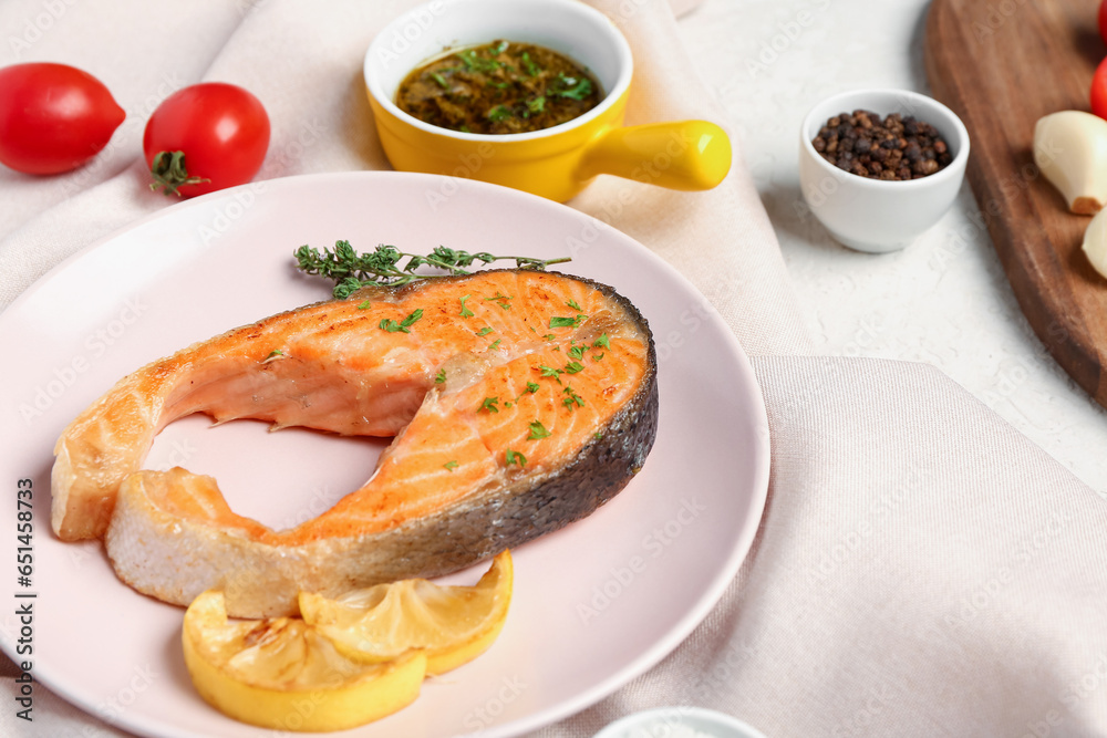 Plate of tasty salmon steak lemon on white background