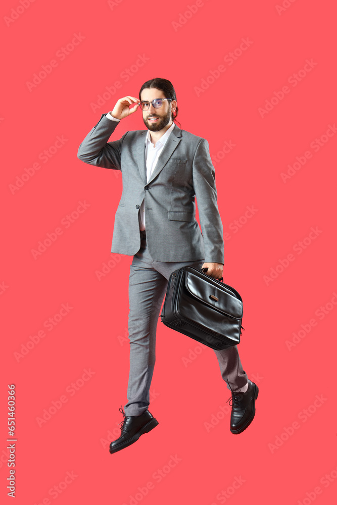 Jumping businessman on red background