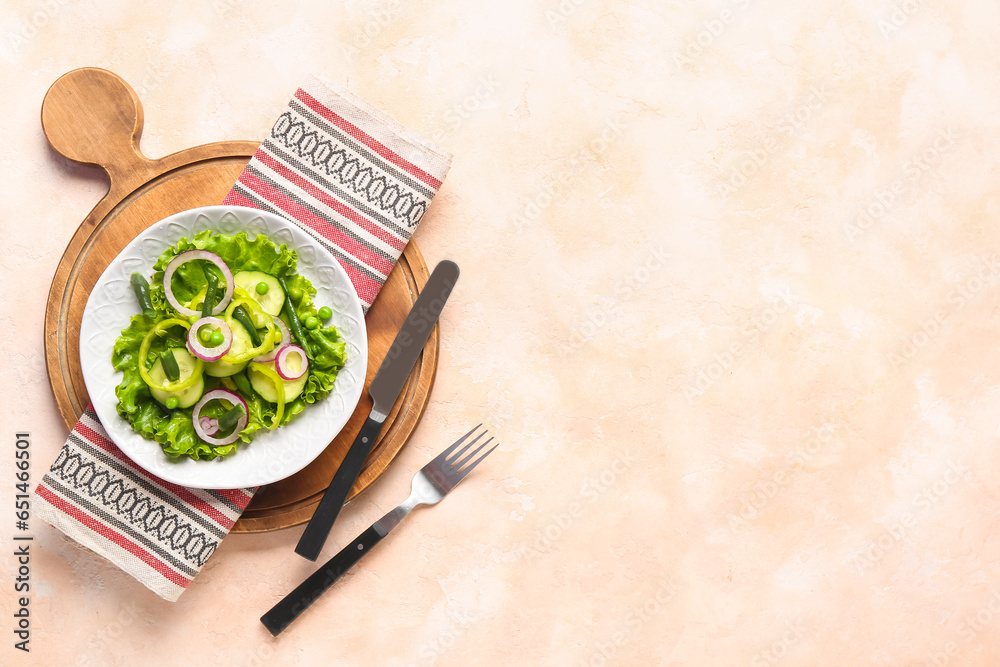 Bowl of tasty vegetable salad on beige background