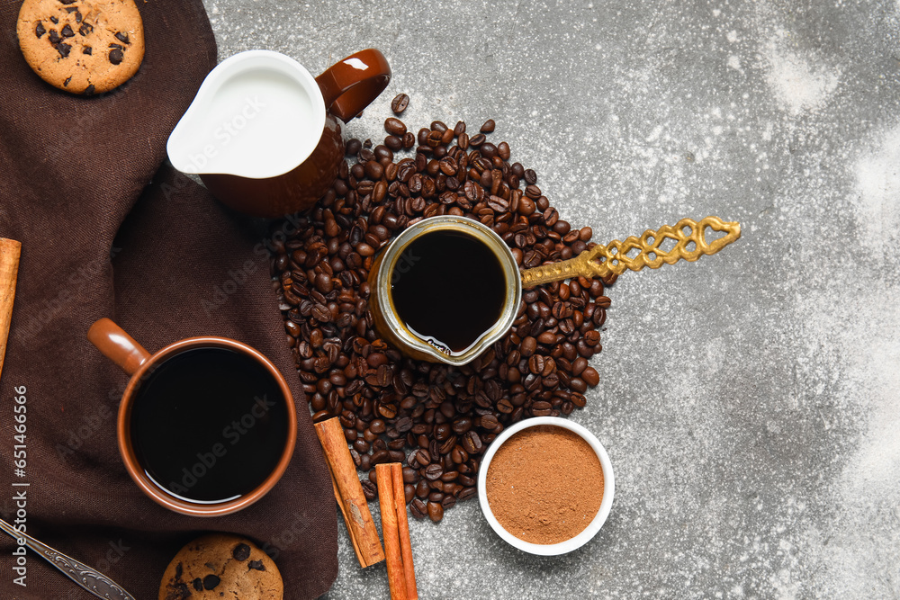 Cup of tasty coffee with cinnamon, milk, cookies and beans on grey background