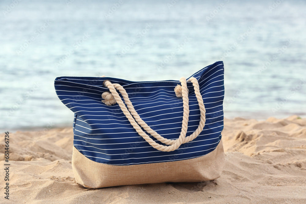 Beach bag on sand near ocean at resort