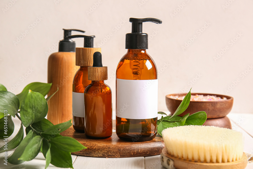 Different bottles of shampoo and brush on table