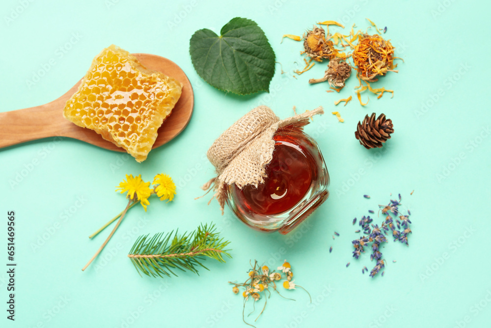 Jar with tasty honey, honeycomb and dried flowers on turquoise background