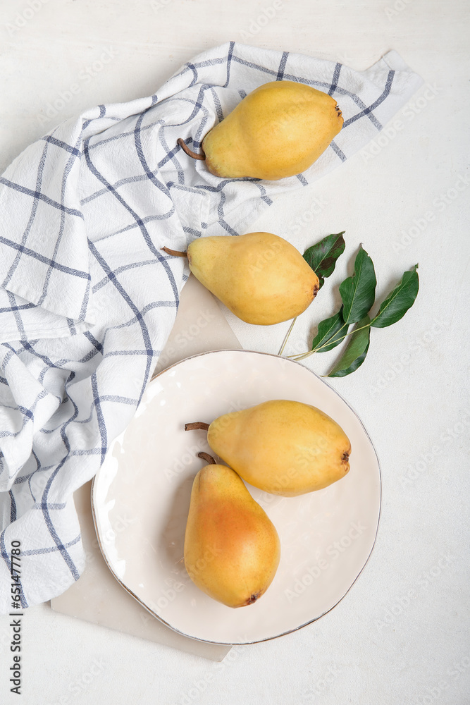 Plate with ripe pears on white background