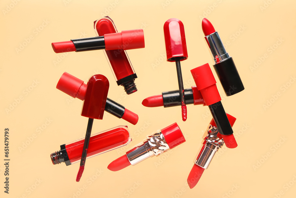 Flying red lipsticks on color background