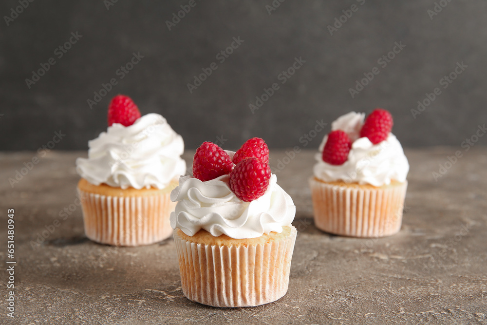 Tasty raspberry cupcakes on table